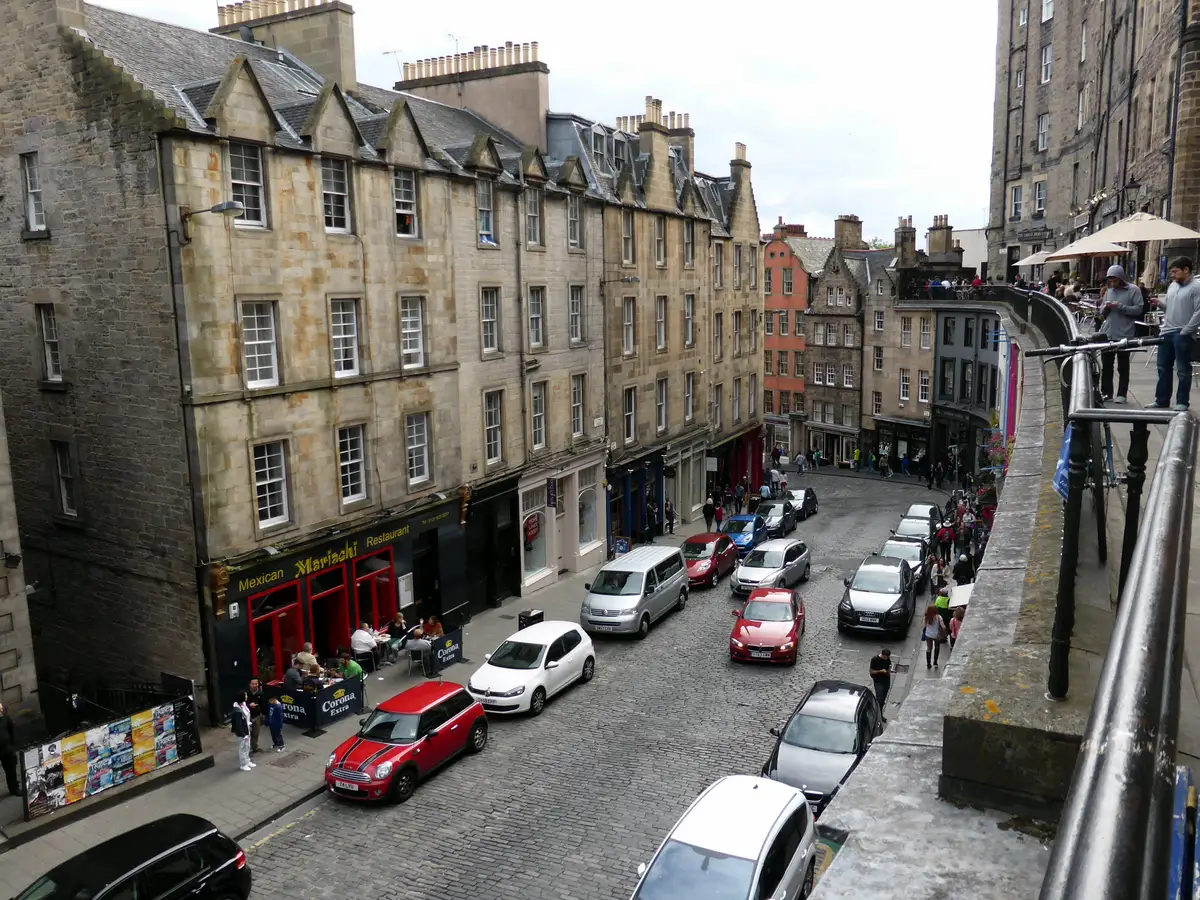 The curve of Victoria Street in Edinburgh, painted shopfronts under the terrace walkway