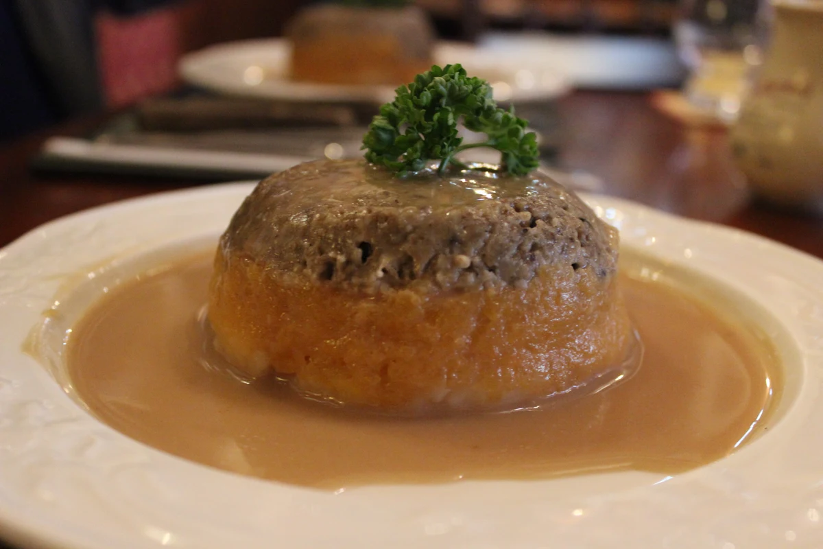 A plate of haggis, neeps and tatties, the three mounds side by side with gravy poured over