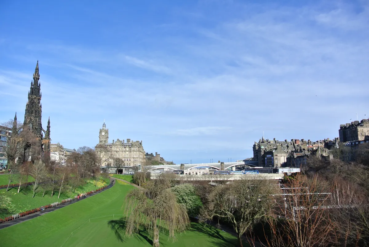 Princes Street Gardens in March, bare trees and fresh grass below the Old Town ridge